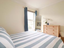A bedroom with a bed and dresser at Flat 5 in Looe