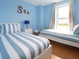 A bedroom with two beds and a lamp at Flat 5 in Looe