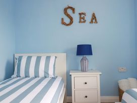 A bedroom with two single beds and a lamp at Flat 5 in Looe