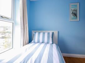 A bedroom with a bed and window at Flat 5 in Looe