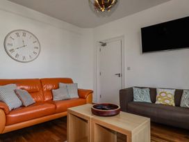A living room with an orange sofa and a coffee table at Sea View in Newquay