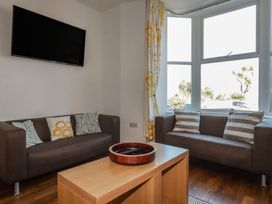A living room with sofas and a television at Sea View in Newquay
