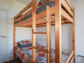 A bunk bed with bedding and a door in the bedroom at Sea View in Newquay