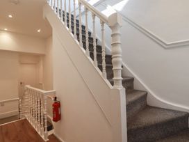 A staircase with a handrail and a fire extinguisher in a hallway at Sea View in Newquay