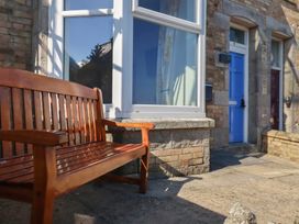 A bench in front of doors and a window at Sea View in Newquay