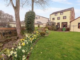 A garden with flowers and a house at High Mill House Penrith