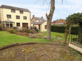 A garden with a house and pathway at High Mill House in Penrith
