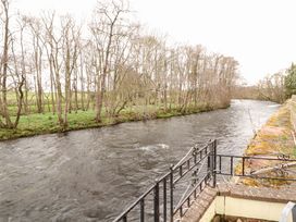 A view of a river with trees along the bank at High Mill House Penrith