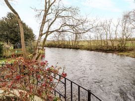 A view of a river with trees and plants at High Mill House Penrith