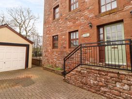 An outdoor view of a stone building and a garage at High Mill House in Penrith