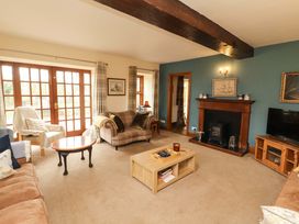 A living room with a fireplace and furniture at High Mill House in Penrith
