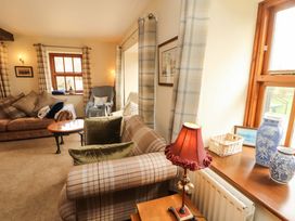 A living room with a sofa and a table at High Mill House in Penrith