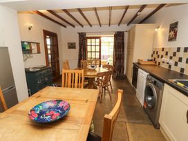 A kitchen with a dining table and appliances at High Mill House in Penrith