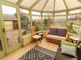A conservatory with seating and a coffee table at High Mill House Penrith