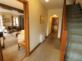 A hallway with a staircase and access to a living room at High Mill House in Penrith