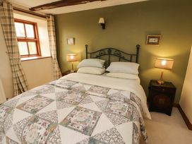 A bedroom with a bed and lamp at High Mill House in Penrith