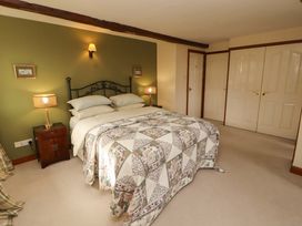 A bedroom with a bed and bedside table at High Mill House in Penrith