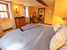 A bedroom with a bed and dresser at High Mill House in Penrith