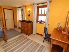 A bedroom with a bed, dresser, and chair at High Mill House in Penrith