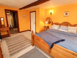 A bedroom with a bed and a dresser at High Mill House in Penrith