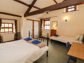 A bedroom with a double bed and single bed at High Mill House in Penrith