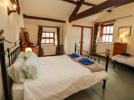 A bedroom with a bed and furniture at High Mill House in Penrith