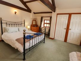 A bedroom with a bed and dresser at High Mill House in Penrith