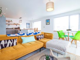 A living room with a sofa and dining area at La Casita in Newquay