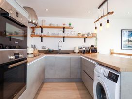 A kitchen with appliances and shelves at La Casita in Newquay