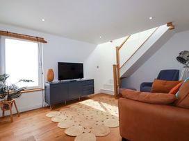 A living room with a television and a staircase at La Casita in Newquay