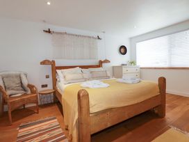 A bedroom with a bed and chair at La Casita in Newquay