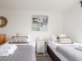 A bedroom with two beds and decorative pillows at La Casita in Newquay