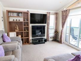 A living room with a television and DVD shelf at 37 Horizon Park Hartlepool