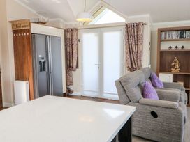 A living room with a refrigerator and sofa at 37 Horizon Park in Hartlepool