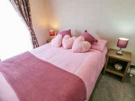 A bedroom with a pink bed and decorative pillows at 37 Horizon Park in Hartlepool