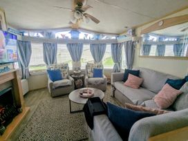 A living room with a sofa and chairs at Lynsey's Coastfields Caravan in Skegness