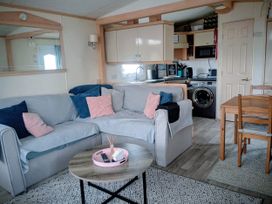A living room with a sofa and dining table at Lynsey's Coastfields Caravan in Skegness