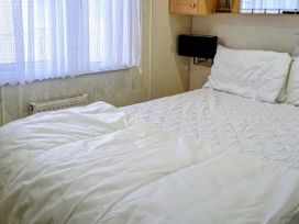 A bedroom with a bed and window at Lynsey's Coastfields Caravan Skegness