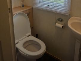 A bathroom with a toilet and sink at Lynsey's Coastfields Caravan in Skegness