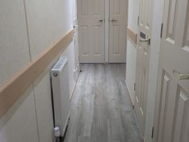 A hallway with doors and a radiator at Lynsey's Coastfields Caravan in Skegness