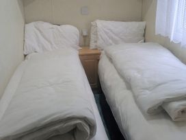 A bedroom with two single beds at Lynsey's Coastfields Caravan Skegness