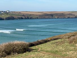 A coastal view with waves and a path leading to the shore at Apartment 29 in Newquay