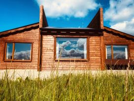 A wooden house with large windows and grass at No 4 Enniskillen