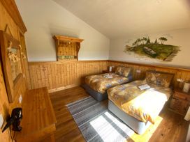 A bedroom with two beds and wooden furniture at No 4 Enniskillen