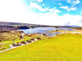 A view of cabins near a lake and grass area at No 4 Enniskillen