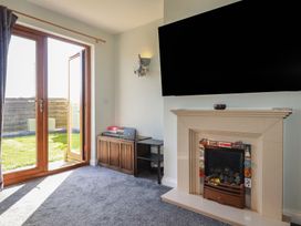 A living room with a fireplace and television at Carnweather in Newquay