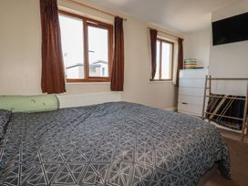 A bedroom with a bed and windows at Carnweather in Newquay