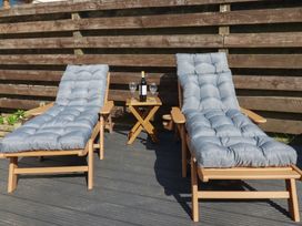 Two deck chairs and a small table with wine and glasses at Carnweather in Newquay