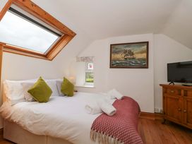 A bedroom with a bed and a television at The Annexe at Cherry Cottage Upton St Leonards