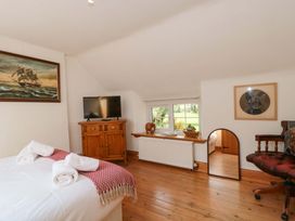 A bedroom with bed, television, and cabinet at The Annexe at Cherry Cottage Upton St Leonards